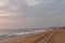 A sand trail of a car in a beach with waves