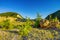 Sand, vegetation with mountain cliffs and blue sky