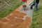 Sand wheeling. garden wheelbarrow carries a worker and pours on piles of beige gravel to repair park, forest, dirt road. erosion c