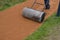 Sand wheeling. garden wheelbarrow carries a worker and pours on piles of beige gravel to repair park, forest, dirt road. erosion c