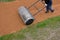 Sand wheeling. garden wheelbarrow carries a worker and pours on piles of beige gravel to repair park, forest, dirt road. erosion c