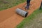 Sand wheeling. garden wheelbarrow carries a worker and pours on piles of beige gravel to repair park, forest, dirt road. erosion c