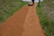 Sand wheeling. garden wheelbarrow carries a worker and pours on piles of beige gravel to repair park, forest, dirt road. erosion c