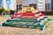 Sand with wooden pyramid with steps which is playground equipment on a public playground in yard in Russia