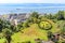 Sandakan town landscape with green lawn in Hindu counterclockwise swastika shape and blue Sulu sea in