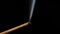 Sandalwood stick with incense smokes on a black background