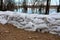 Sandbags flood protection holding back river during flood