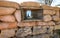 Sandbags of a trench to protect army soldiers and the narrow loophole from which the ossuary of Mount Cimone