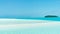 Sandbar in turquoise water, blue sky, white sand, island palm trees. South Pacific Ocean. People walking far alway on sandbank.