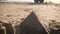 Sandcastles in shape of pyramids on a beach.