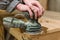 Sander. Sand wooden products. A man works with a grinding machine. Carpentry workshop