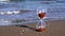 Sandglass clock with golden grains stands on sunny beach