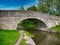 Sandstone Bridge 23 on a quiet, rural section of the Leeds to Liverpool Canal in Lancashire, UK.