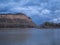 Sandstone Cliffs Along a River with Storm Clouds Overhead