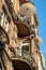 Sandstone facade with historic balcony and parasol for a summer sunbath in historic house