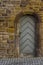 Sandstone historic city wall with wooden door and door frame with sandstone round arch carved with special lock