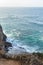 Sandstone path overlooking cliff side, pacfic ocean expanse, and waves on the shore