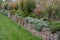 Sandstone walls and stones in a flowerbed in a terraced terrain with stairs. flowering rocks and stairs with a gravel surface. her