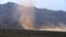 Sandstorm tornado raging in desert, mountains looming in background