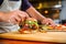 sandwich artist placing a bun on a grilled veggie burger