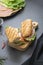 Sandwich with baguette bread, ham, lettuce, tomatoe over dark background. Breakfast or fast food