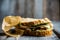 Sandwich with cereal bread, chicken, pesto and cheese on the rustic wooden background