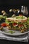 Sandwich with chicken, cherry tomatoes, quail eggs and microgreens against a dark background, Vertical orientation