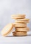 Sandwich cookie consisting of two chocolate wafers with cream filling with glass of milk on stone background