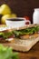 A sandwich cutting board sits on a brown wooden table