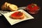 Sandwich with delicious red salmon caviar on white porcelain plate of unusual shape, white baguette on paper napkin with geometric