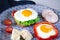 Sandwich with egg, ham, cheese, toast and salad leaves lies on a plate with tomato and dill