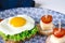Sandwich with egg, ham, cheese, toast and salad leaves lies on a plate with tomato and dill