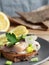 Sandwich herring in vinegar, served with onions, parsley and lemon. Copyspace. Vertical orientation, close up