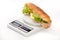 Sandwich with letuce and ham on the digital scale