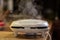 The sandwich maker is smoking. Steam comes out when making sandwiches