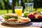 sandwich next to fruit bowl on a sunny picnic table