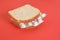 sandwich with packs of pills instead of filling, red background, treatment concept