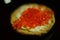 Sandwich with red caviar and butter on a black background blur place