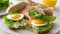 A sandwich with salmon, eggs, and lettuce on a white plate