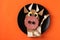 Sandwich with sausage and egg in the shape of a funny bull, symbol of the new 2021 on bright orange background, culinary