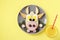 Sandwich with sausage and egg in the shape of a funny bull, symbol of the new 2021 on yellow background, culinary idea for