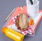 A sandwich with sausages and salad in a lunch box with vegetables and fresh juice in a bottle. Delicious and healthy lunch for