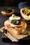 Sandwich with slice of mozzarella cheese and tapenade, caper on dark rustic table background. Traditional Provence dish.