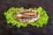 Sandwich with sprots and rye bread on lettuce leaves and concrete background