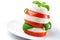 A sandwich of tomato and mozzarella slices decorat