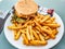 Sandwich with very seasoned meat burger in a plate with french fries