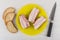 Sandwiches with bacon in plate, pieces of bread, kitchen knife