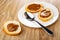 Sandwiches from bread with boiled condensed milk, spoon in plate, sandwich on wooden table