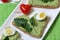 Sandwiches for breakfast. Heart-shaped bread slices smeared with ground avocado.