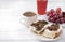 Sandwiches with cheese and mushrooms, glass of juice, 1  Cup of black coffee, grapes on a white ,   healthy Breakfast, copy space